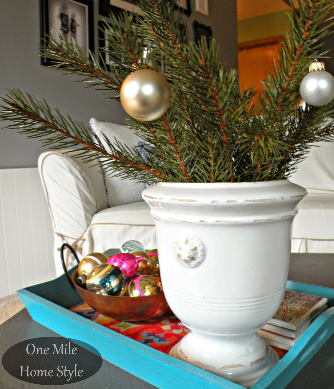 Christmas greenery with a copper bowl of vintage Christmas ornaments