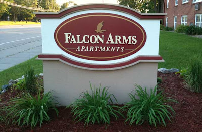 Nicely made oval sign with large letters reading Falcon Arms Apartments