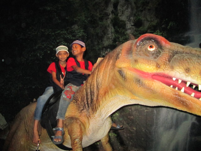 Children from Rumah Titian Kasih riding the T-Rex at Dinoscovery