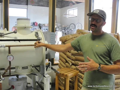 co-owner Adam Dick with grinding ball mill at Dick Taylor Craft Chocolate in Eureka, California