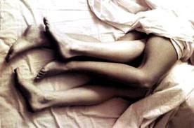 pareja desnuda bajo las sábanas
