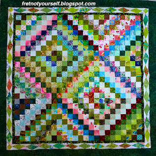 Scrappy Trip quilt made of mainly greens and pinks.