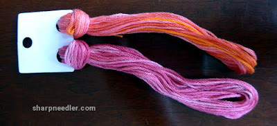 Pair of variegated House of Embroidery threads in pinks/oranges.