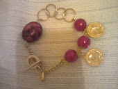 pulseira dourada,pedra vermelha ,elos perola e medalhas