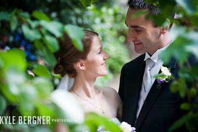 Bride and Groom surrounded by leaves in the side garden at Chase Court