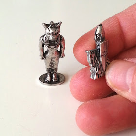 Small metal ornamental Egyptian cat figure and a small metal knight figure on a horse.