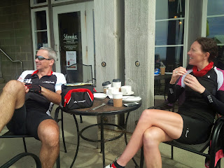 Two cyclists enjoying a break and having a coffee.