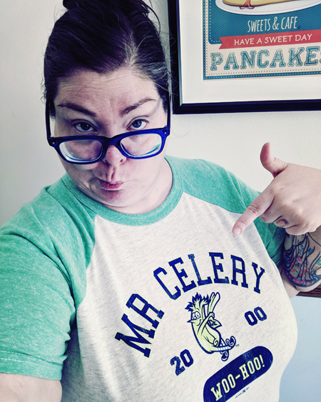 image of me from mid-torso up, making a silly face with my glasses balanced on the edge of my nose, wearing a baseball tee with green arms and a celery mascot on it
