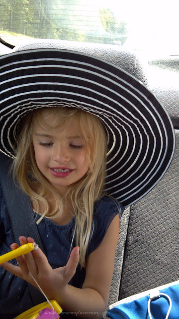 Little girl in her grandmother's big hat.