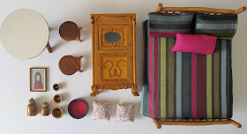 Selection of modern pink, red and wooden dolls' house miniatures arranged on a desktop.