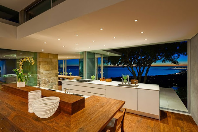 Panoramic Night View near Modern Home Kitchen with White Counter and Wooden Stools
