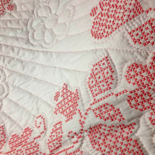 pink cross stitched quilt: QuiltBee
