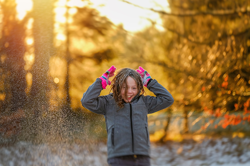 image of a girl playing in the snow captured with a Fuji X system camera and the Fujinon 50-140mm by Willie Kers