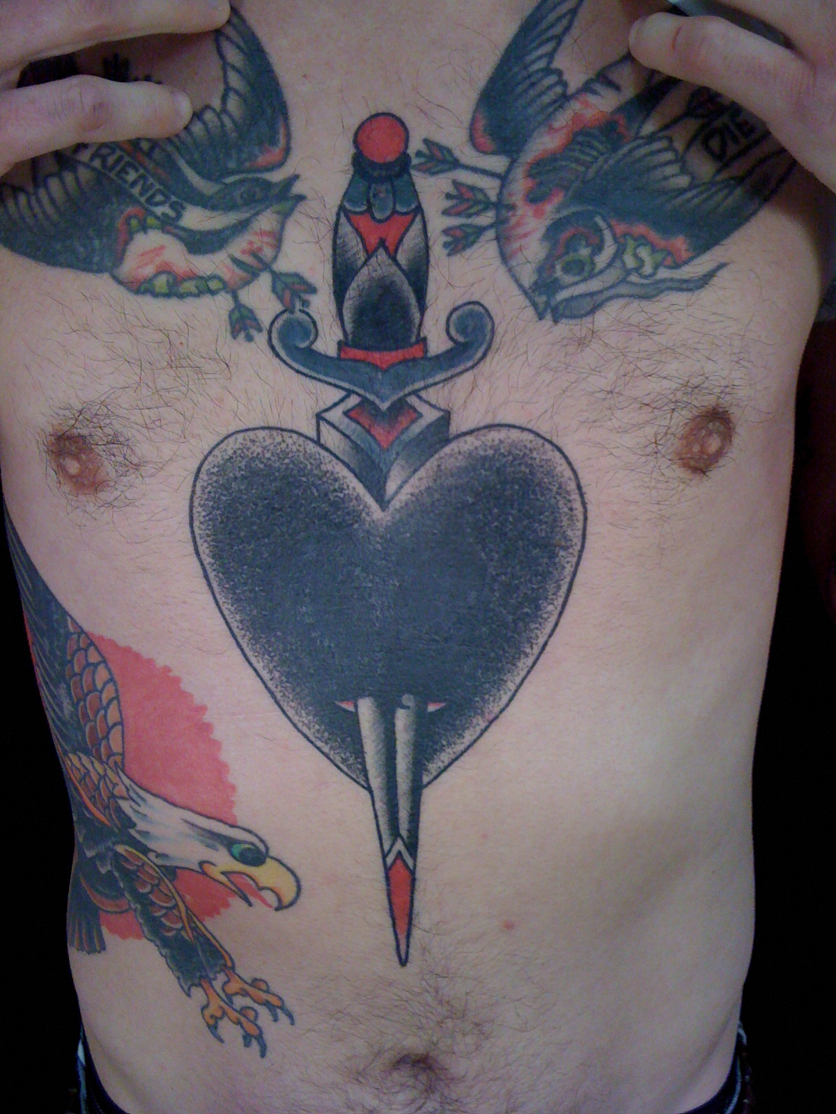 Jeb Maykut - Flyrite Tattoo: Black heart with dagger chest tattoo