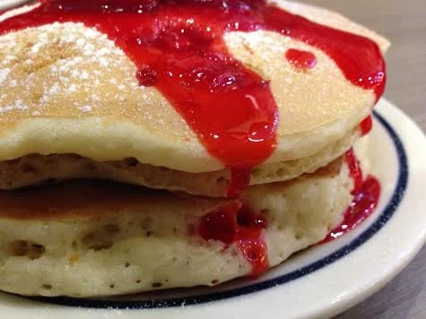 IHOP Strawberry syrup dripping over the pancake