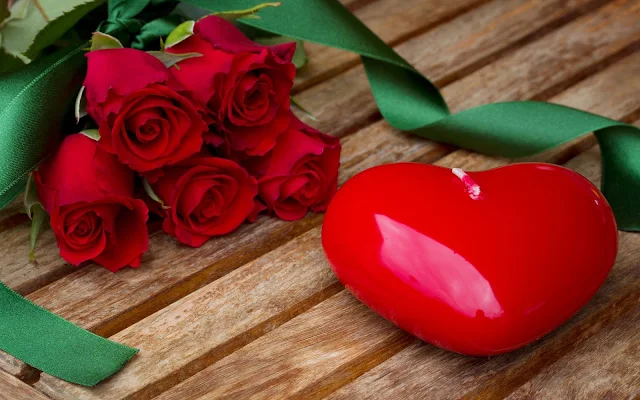 Rode kaars in de vorm van een liefdes hart en rode rozen