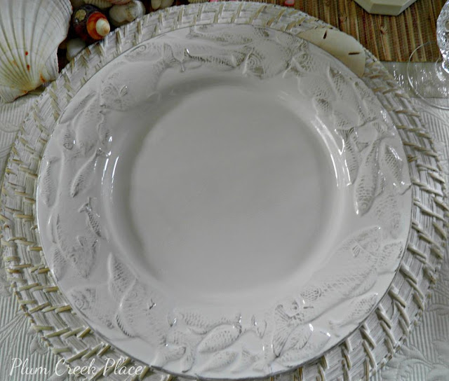 White fish embossed dinner plate with white washed charger plate