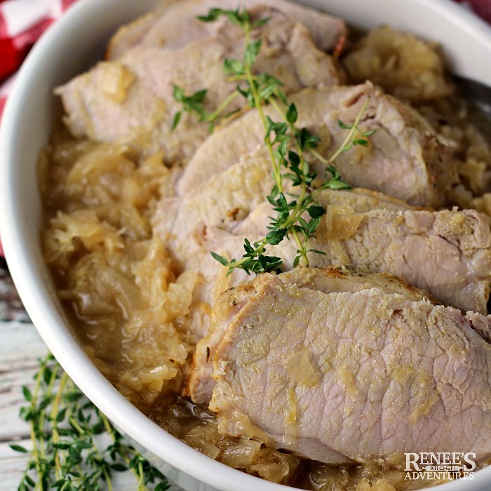 Pork and Sauerkraut in serving dish topped with sprigs of fresh thyme