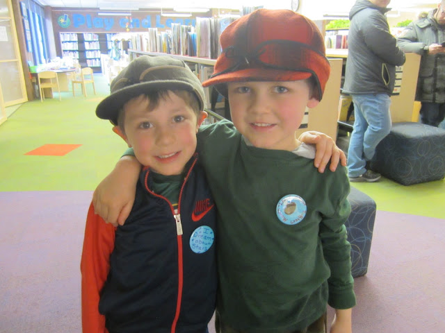 two boys with their arms around each other showing off their buttons.  One button reads:  I dream about stars