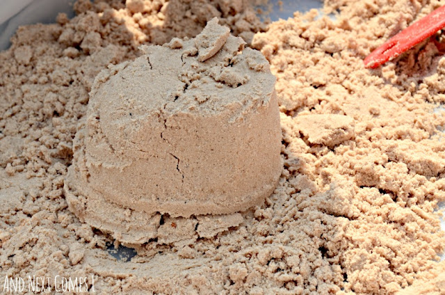 Chocolate peppermint cloud dough molded into a shape in a sensory bin