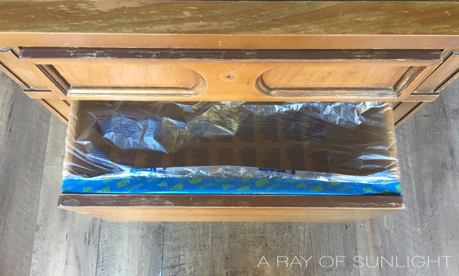 How to prep furniture for paint by taping off your furniture for a paint sprayer. This is the best way to spray your furniture without getting overspray inside the drawers and cabinet spaces. How to Use a Paint Sprayer on Furniture by A Ray of Sunlight