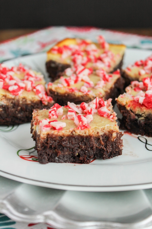 Impress your holiday guests with these Peppermint Cheesecake Brownies! Ooey gooey fudgy brownies are topped with a layer of peppermint infused cheesecake. Top that off with sprinkles of peppermint pieces, and you've got one delicious, decadent, and fun holiday dessert!