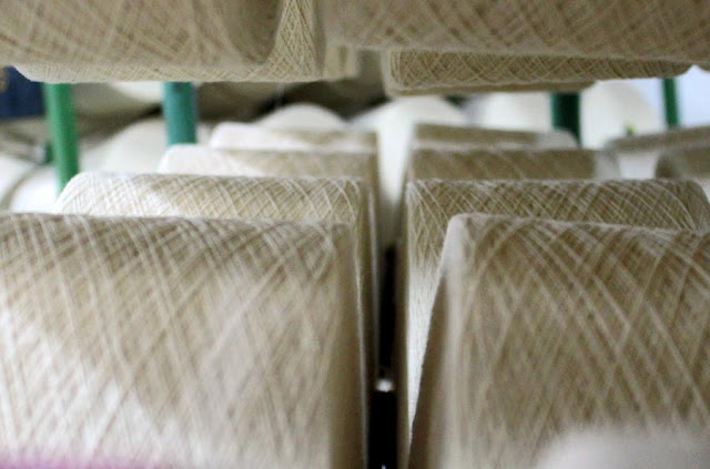 spools of white thread in a cotton mill