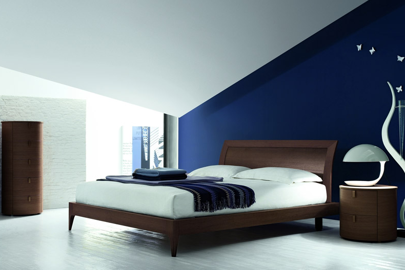 Il letto rovere moro su una parete blu cobalto