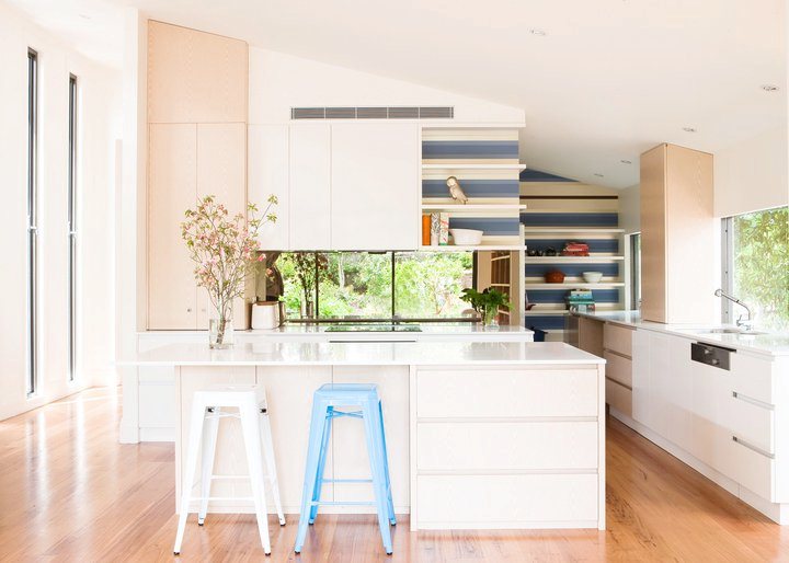 kitchen with blue and white backsplash, white island, wood floors and 