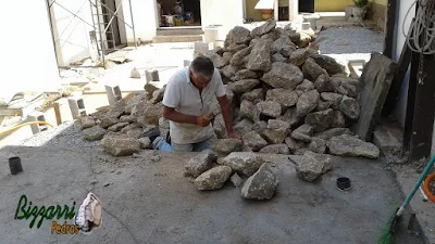 Bizzarri acertando a pedra para fazer um murinho de pedra com pedra moledo com as escadas de pedra, os caminhos de pedra em construção com pedra em São Paulo-SP.23 de setembro de 2016.