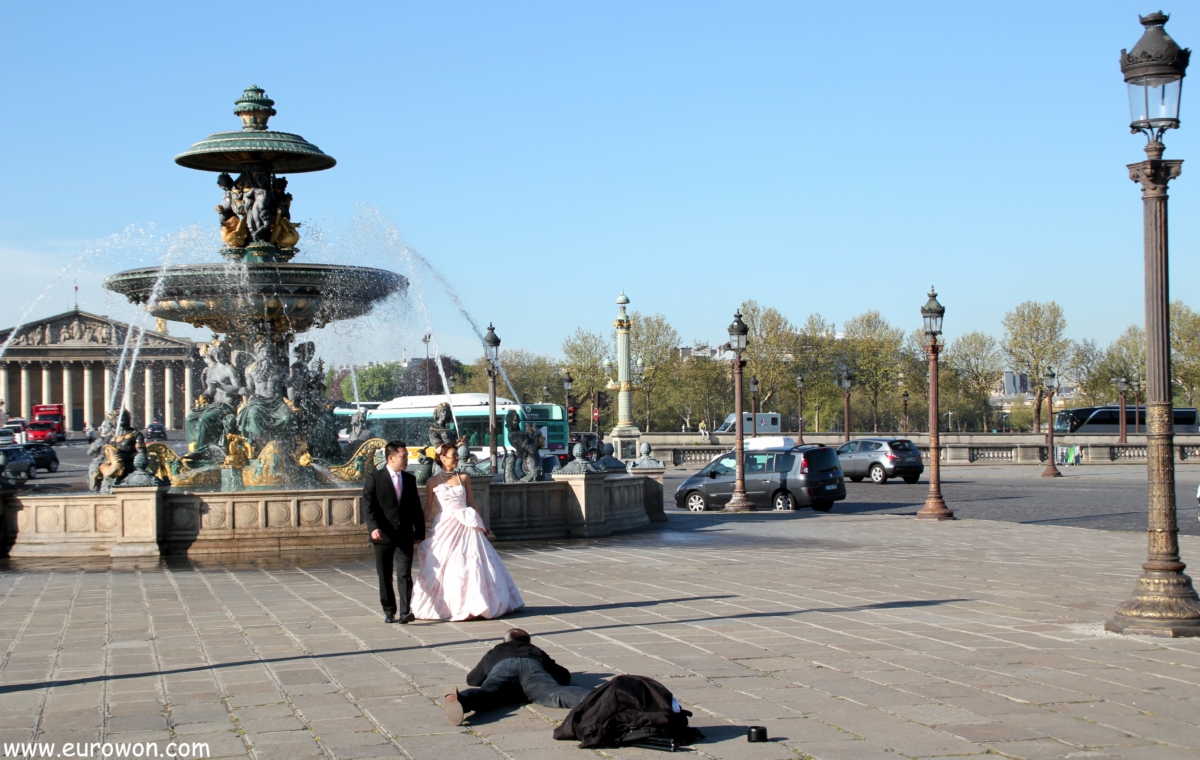 Pareja de recién casados asiáticos tomándose fotos en la plaza de la Concordia