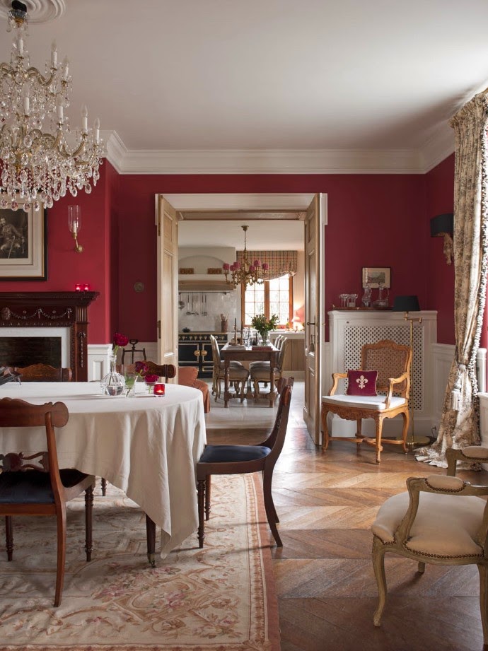 Red walls in a dining room in Belgium by Greet Lefevre.