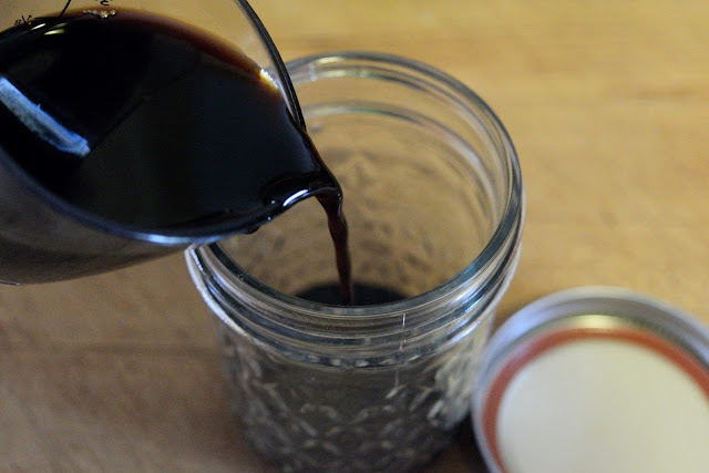 Soy sauce being poured into a mason jar.