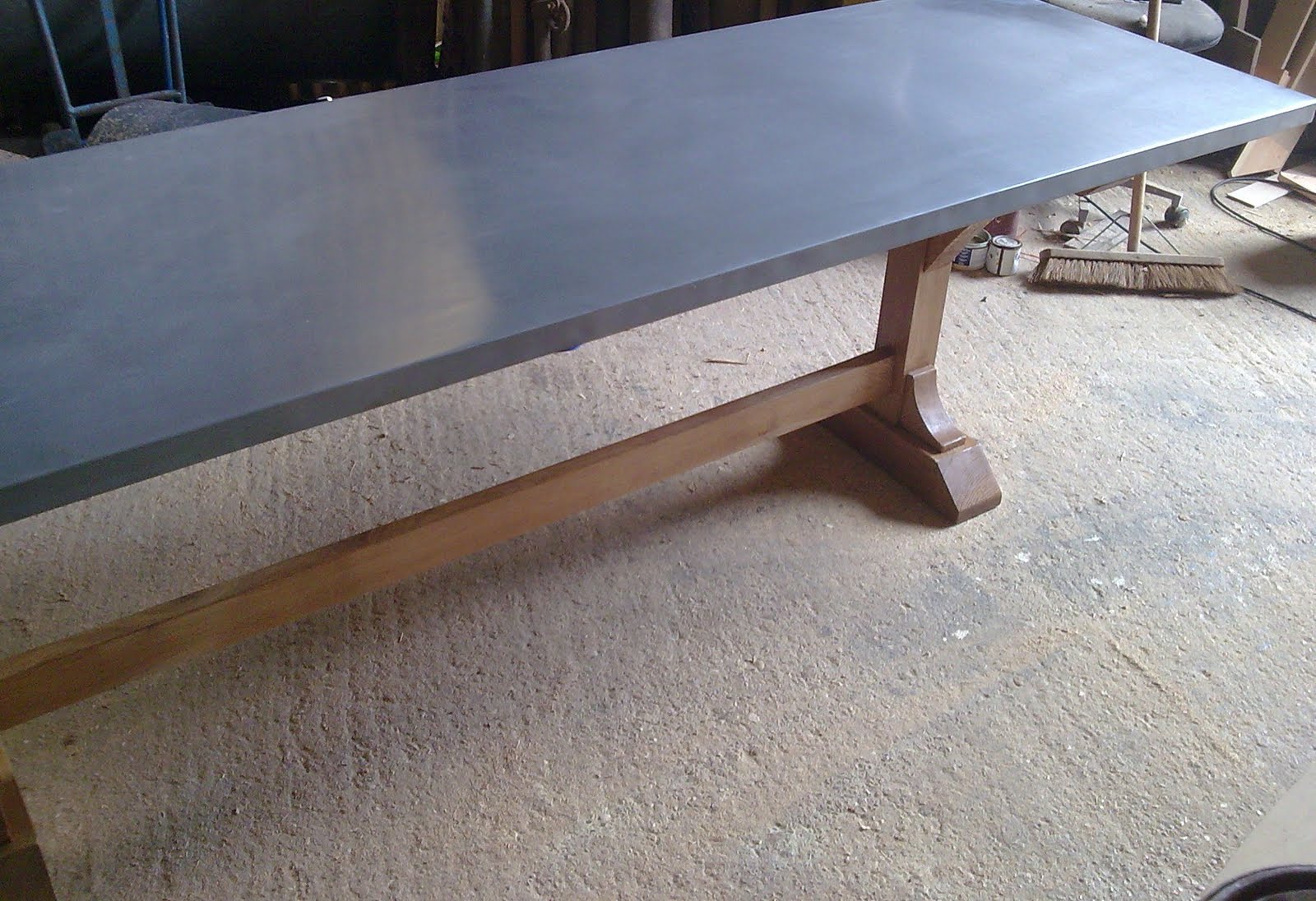 Deballage Designs Oak based trestle table with a burnished zinc top