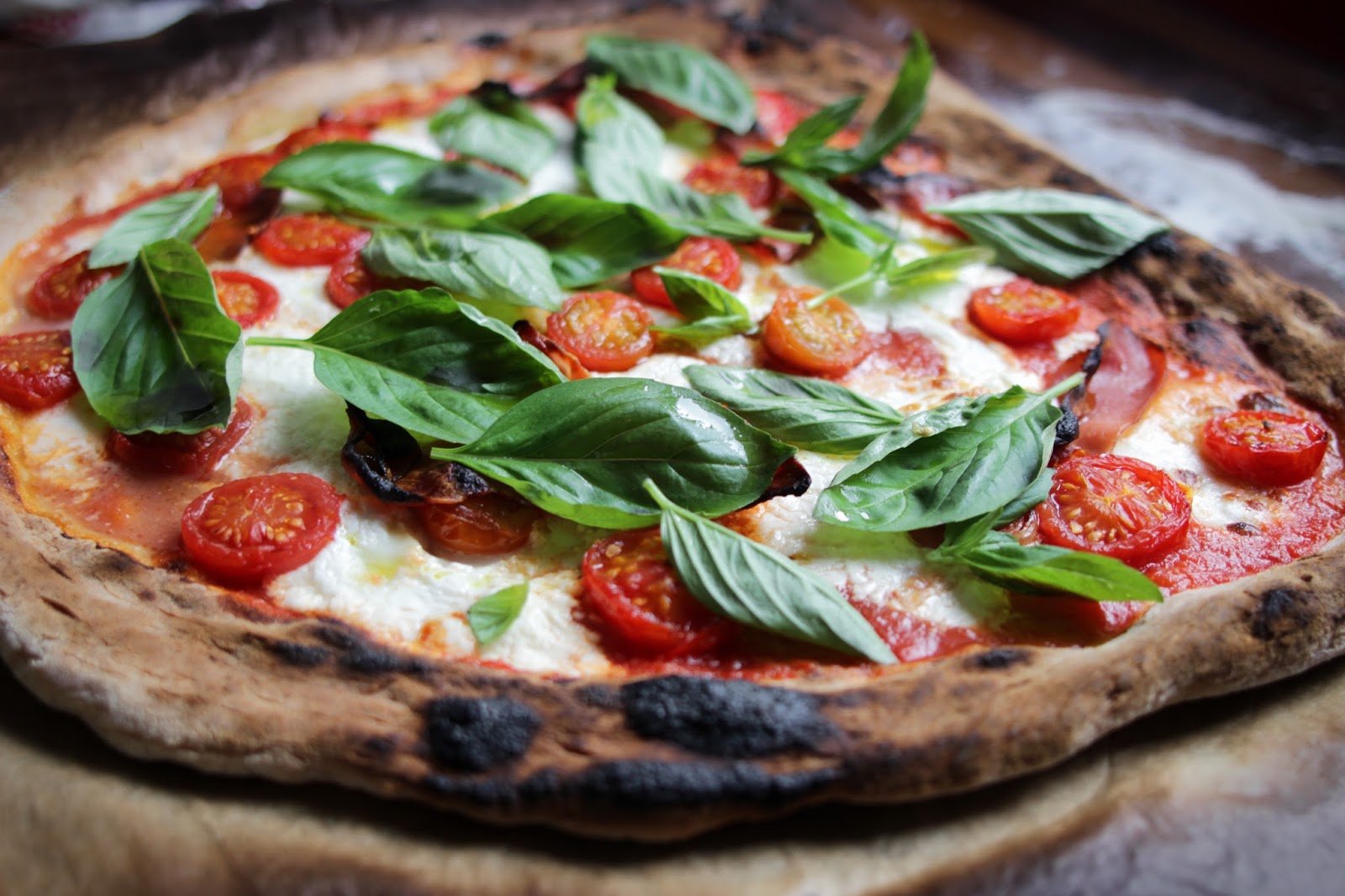 Pizza caseira com tomate, burrata, presunto e manjericão Homemade