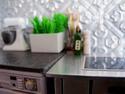 Modern dolls' house miniature kitchen with grey laminate bench.