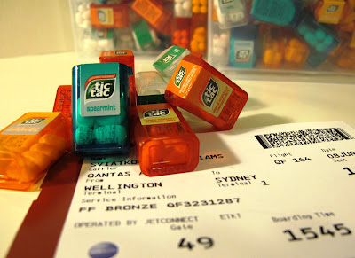 Airplane boarding pass with a pile of Tic Tac minis piled on it.