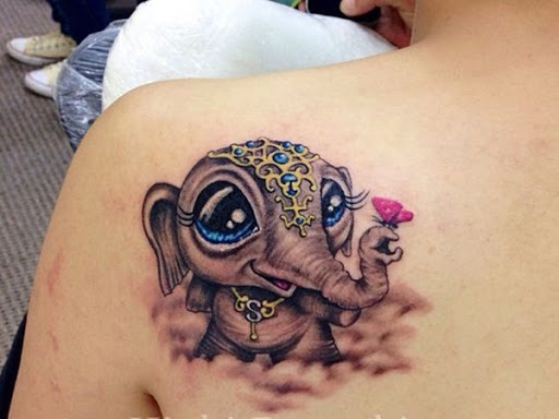 Oversized olhos, normalmente, criar um bonito efeito em ilustrações, como visto neste tatuagem de um elefante vestindo um cocar e segurando uma flor.