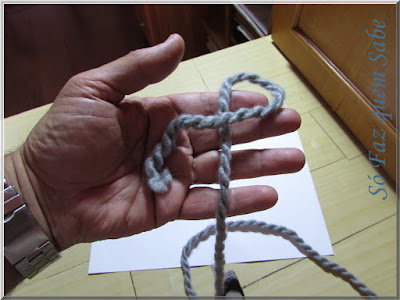 Foto mostrando um fio com um laço na palma da mão para execução de um nó corrediço