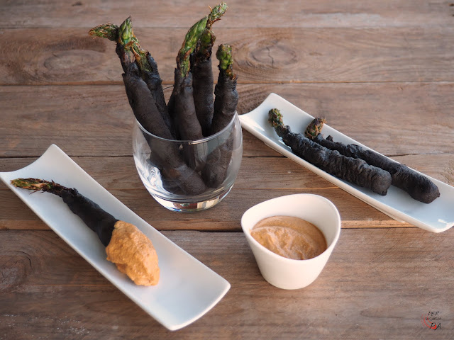 Espárragos rebozados en una masa con tinta de sepia y acompañados de salsa romesco