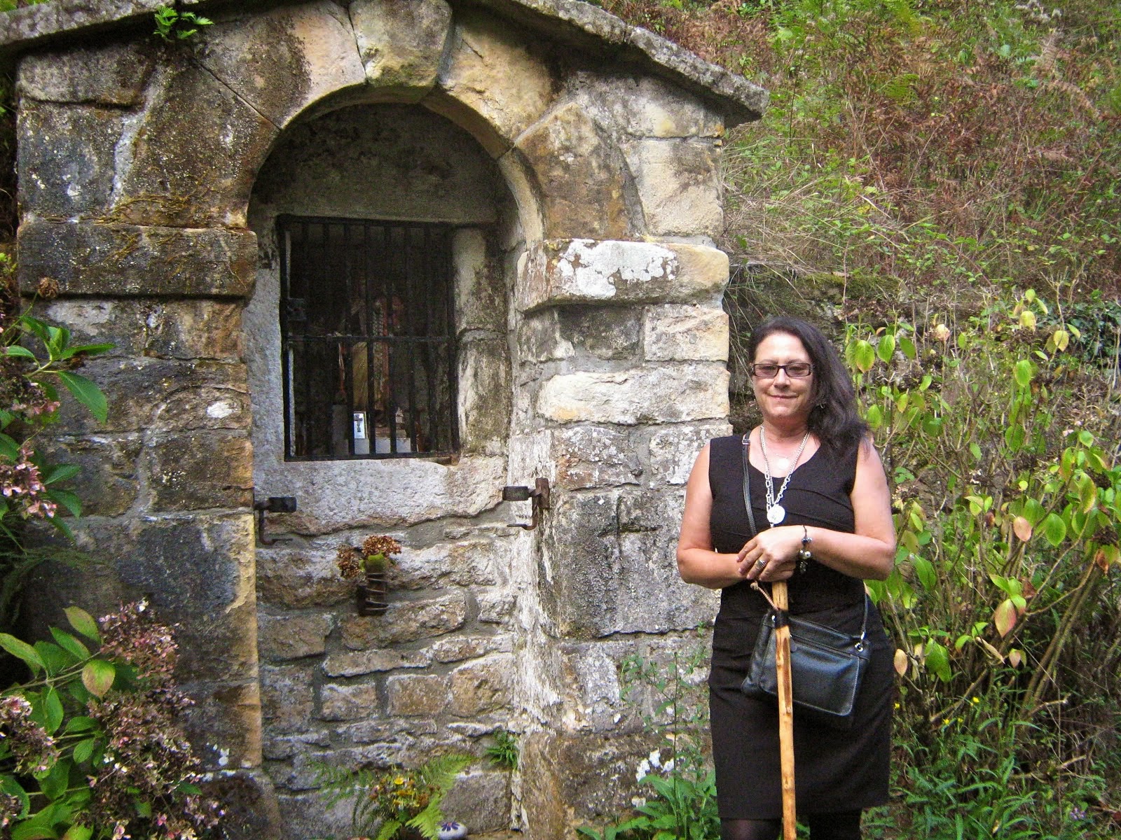 Castaños, flores, un camino y una capilla de ánimas.