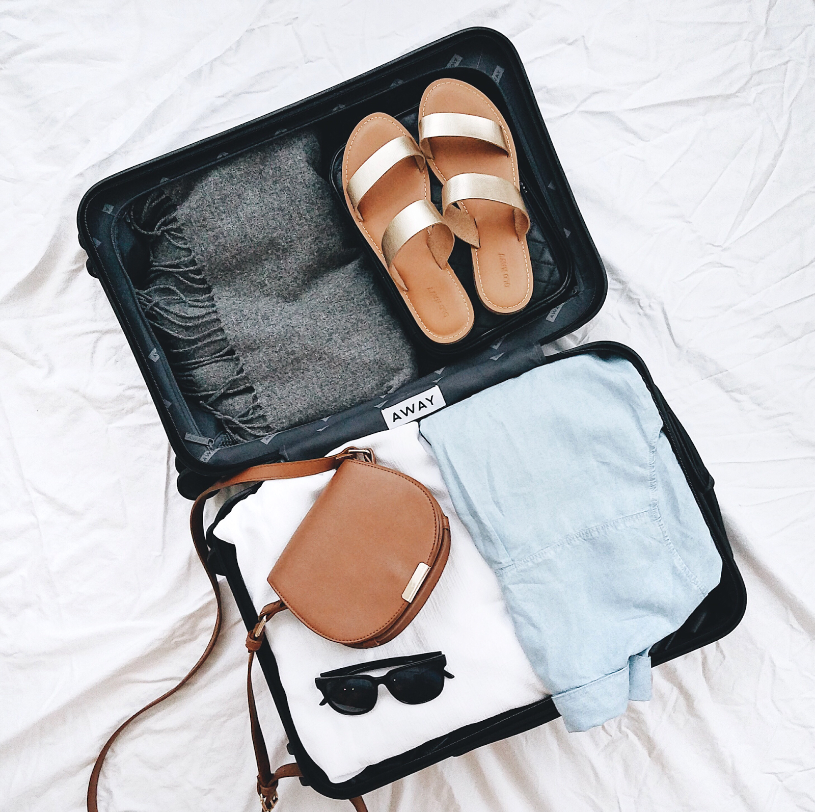 Weekend travel essentials tucked cleanly into a modern Away rolling suitcase.