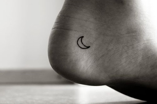 Um esboço de uma lua crescente é retratado em que o portador do calcanhar esquerdo desta tatuagem.