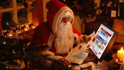 Santa Claus revisa la lista de regalos en su pc para Navidad