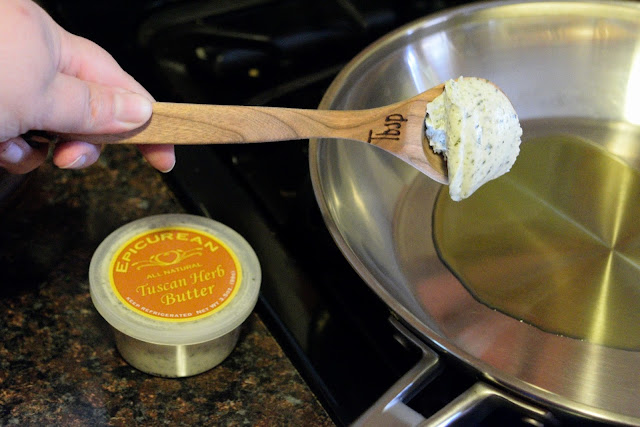 A tbsp. of the Epecurian Tuscan Herb Butter being added to the skillet on the stove.