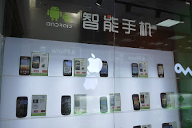 Android display case of a variety of phones reflecting the Apple logo in the Android Store in Nanping, Zhuhai, China