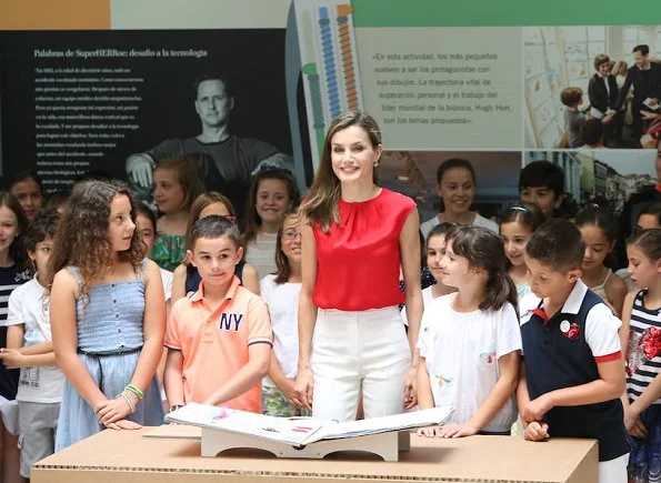 Queen Letizia wore Dutti Trousers, Carolina Herrera red satin blouse, and Mango perforated design sandals. carried Uterque snakeskin clutch (Summer 2013 collection)