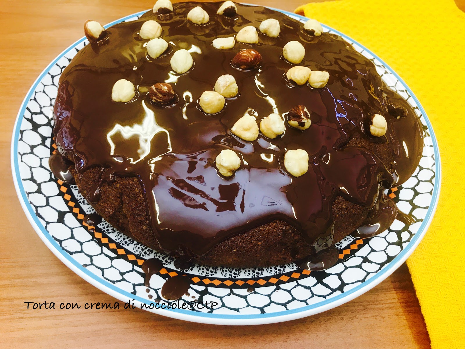 torta con crema di nocciole alessandra ruggeri La torta con crema di nocciole e' un dolce perfetto per il periodo invernale estremamente sfizioso, dal sapore intenso, che saprà conquistare davvero tutti dai più' grandi ai più' piccola sarà' per la presenza della crema d nocciole o per la cioccolata di copertura è un dolce che e' perfetto anche per le feste Natalizie. Torta con crema di nocciole ricoperta di nocciole Burro morbido 100 g Zucchero di canna 90 g 2 Uova 1 Tuorlo Farina 100 g Farina di nocciole 100 g Crema di Nocciole 100 g 1 bicchiere di latte 1 cucchiaio di lievito 50 g di gocce di cioccolato Cioccolato fondente fuso 100 g Nocciole intere 60 g In una ciotola capiente, sbattete lo zucchero di canna con il burro morbido fino ad ottenere un composto spumoso. Aggiungete le uova una alla volta continuando a sbattere ed infine unite anche il tuorlo. Aggiungete al composto le farine e il lievito, incorporate anche la crema di nocciole, versate il latte e continuate a mescolare. Unite le gocce di cioccolato.Versate il composto in una tortiera ricoperta da carta da forno e cuocete in forno già caldo a 180° C per 45 minuti. Nel frattempo, sciogliete il cioccolato fondente a bagnomaria o nel microonde. Sfornate la torta e glassatela con il cioccolato fuso, decorando con le nocciole intere. Nota della cuoca " Assolutamente da provare con un accompagno di anna ma anche con una salsa di lamponi" Alessandra...........Bon Appétit !!!