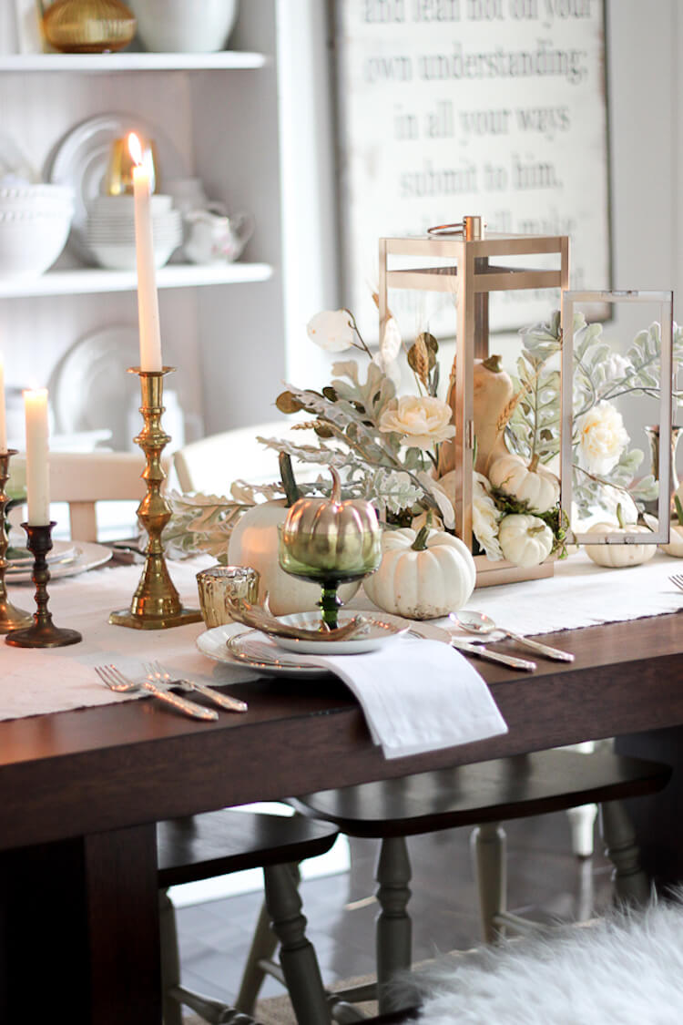 Mesa decorada con calabazas, candelabros y detalles en dorado