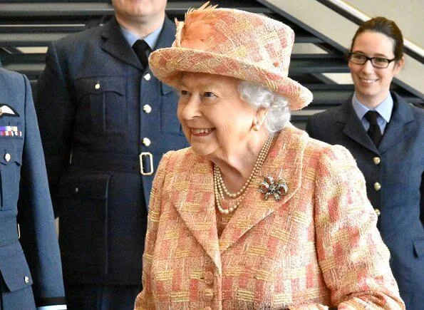 As Honorary Air Commodore, Queen Elizabeth. She wearing a peaches and cream outfit with matching hat by Angela Kelly. diamond bow brooch